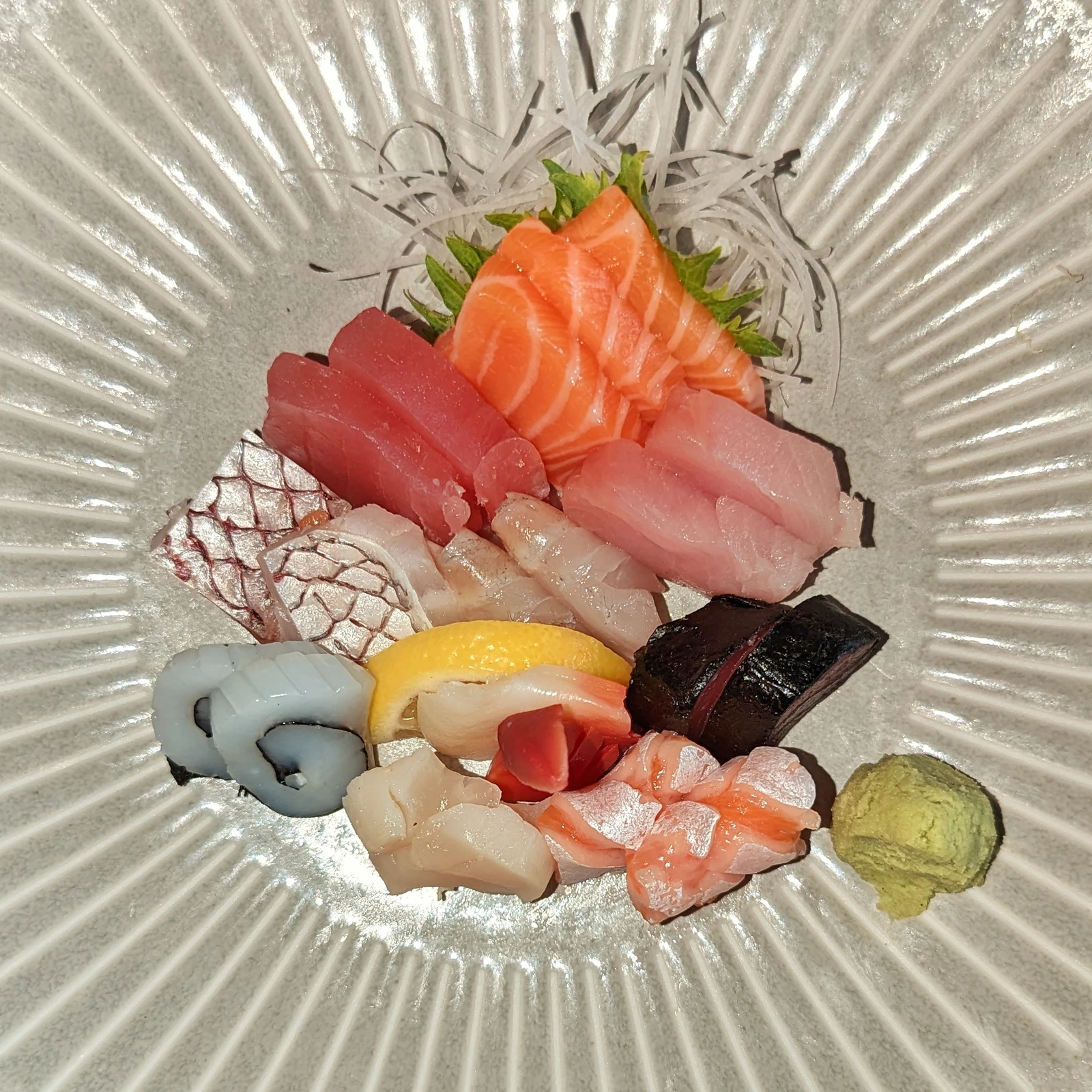 Piatto di sashimi vario con daikon, shiso e salsa di soia